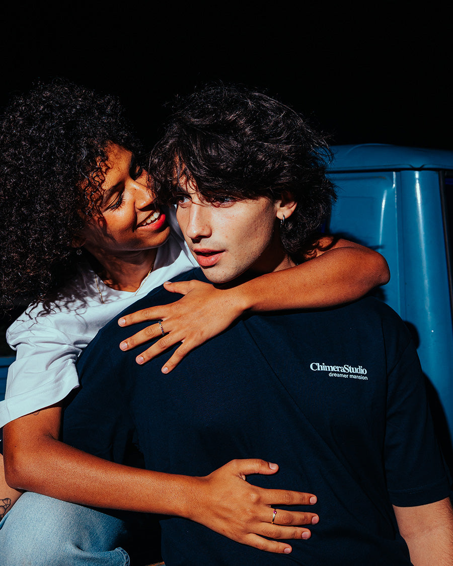 Two people embracing with a blue vehicle in the background